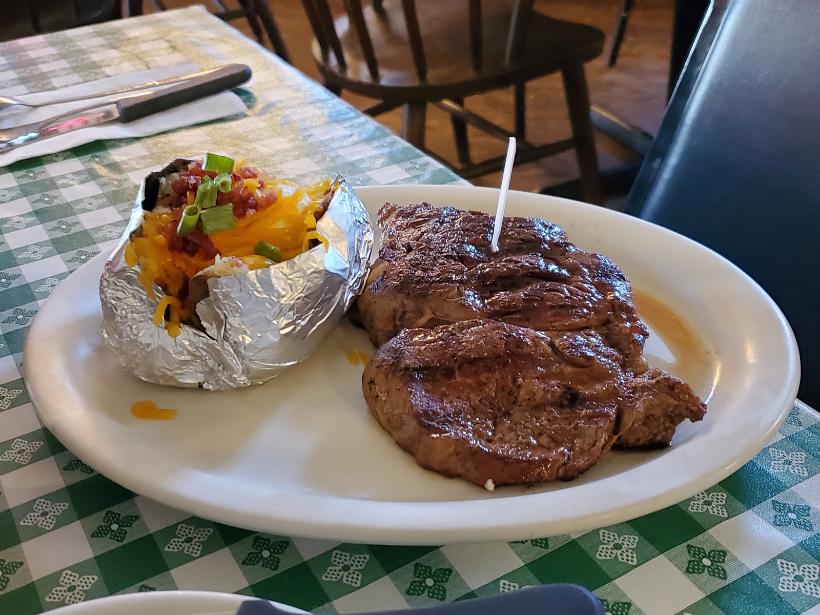 Grilled ribeye steak with a loaded baked potato