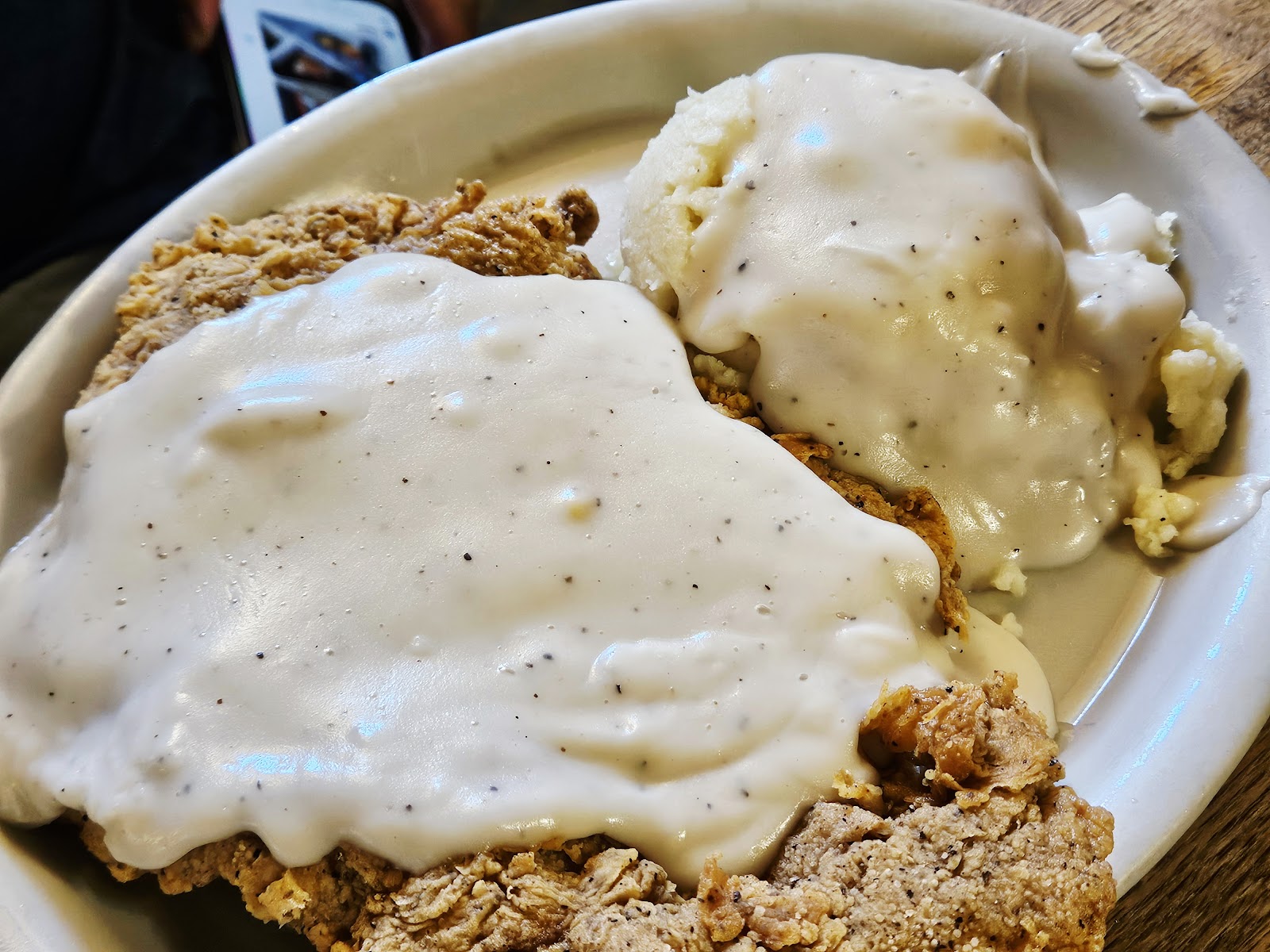 Chicken fried steak smothered in cream gravy with mashed potatoes